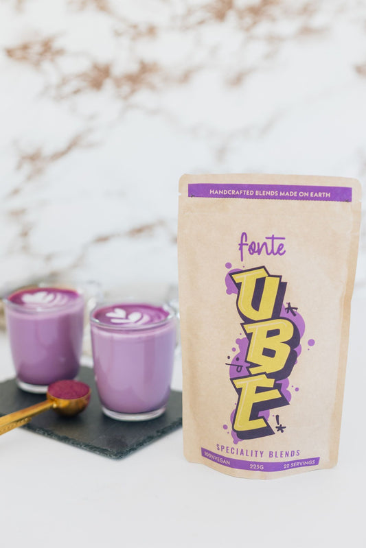 Ube Latte caliente con latte art junto al paquete de FONTE de 225 gr.